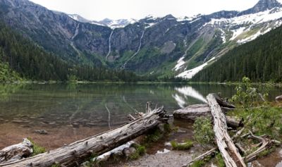 A lake in front of snow capped mountains.